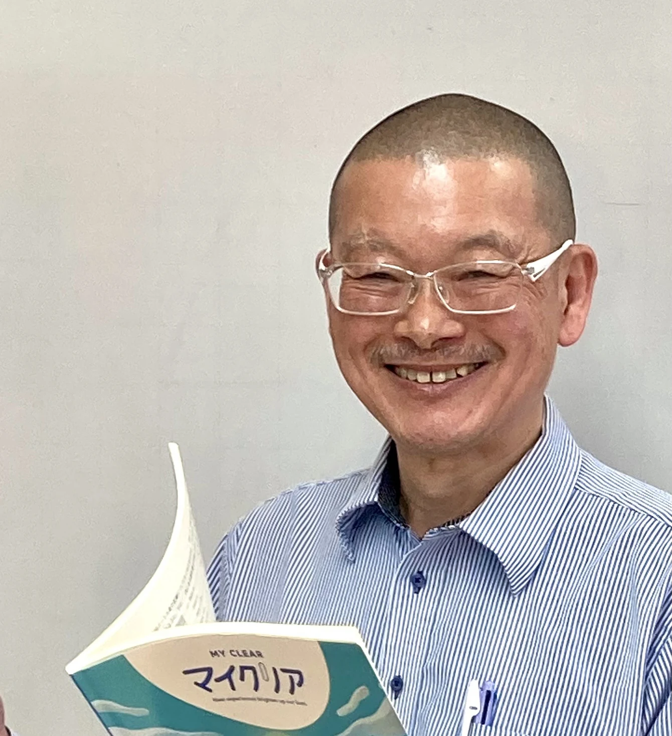 教材を手に笑顔を見せる2026年の伊藤先生